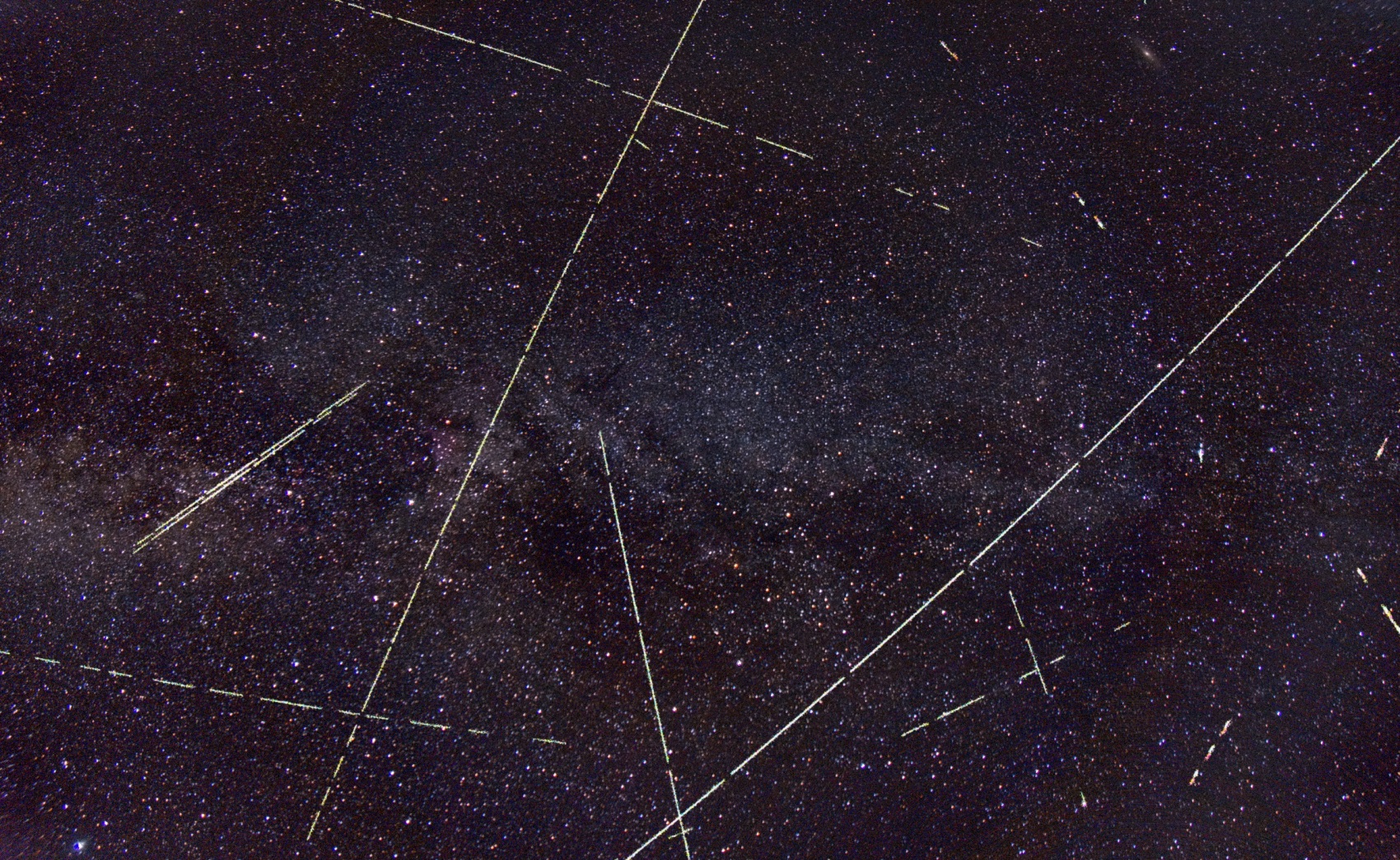 The Milky Way star field with many long straight bright trails crossing it in all directions